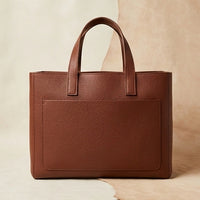 Elatheria Hearthstone pebbled full grain tan leather firewood carrier, hero angle view