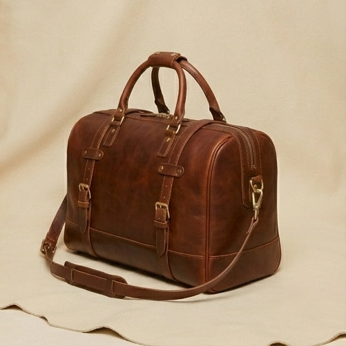 The Voyager leather duffle — hand-stitched seam and grain texture close-up