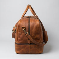 The Match Point leather tennis duffle bag — side profile showing shoe compartment seam