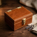 The Keepsake leather pet ID tag and memory box, closed, premium studio shot with dried lavender