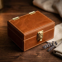 The Keepsake leather pet ID tag and memory box, closed, premium studio shot with dried lavender