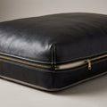 Close up corner detail of The Haven black leather dog bed showing brass zipper pull