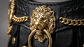 Gold lion emblem and chain detail close-up on The Regal leather dog collar