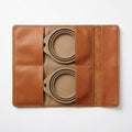 The Voyager rolled leather case side angle beside a leather travel bag and car keys
