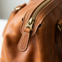 Zip closure and leather pull detail on The Voyager pet tote
