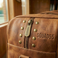 Close-up of zipper pull, rivets, and stitching on The Match Point leather duffle