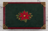 Red poinsettia Christmas embroidery on the green leather lid of The Heirloom Christmas