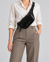 Black crocodile-embossed leather sling bag worn crossbody with an adjustable strap